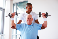 caregiver assisting patients in lifting weights